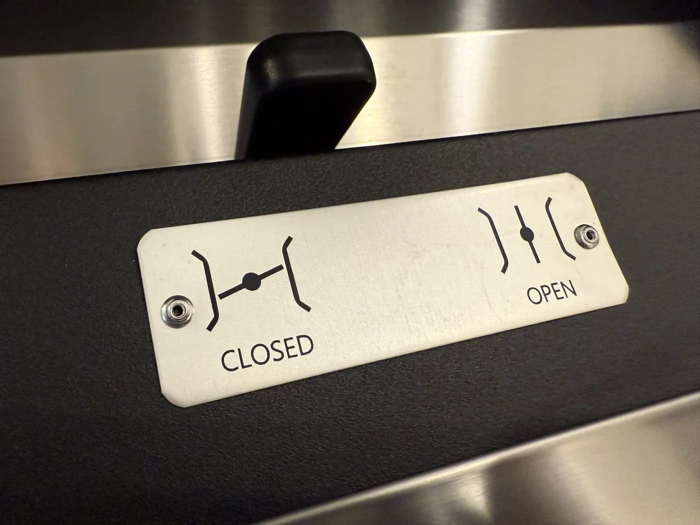 The steam damper lever, engraved CLOSED and OPEN